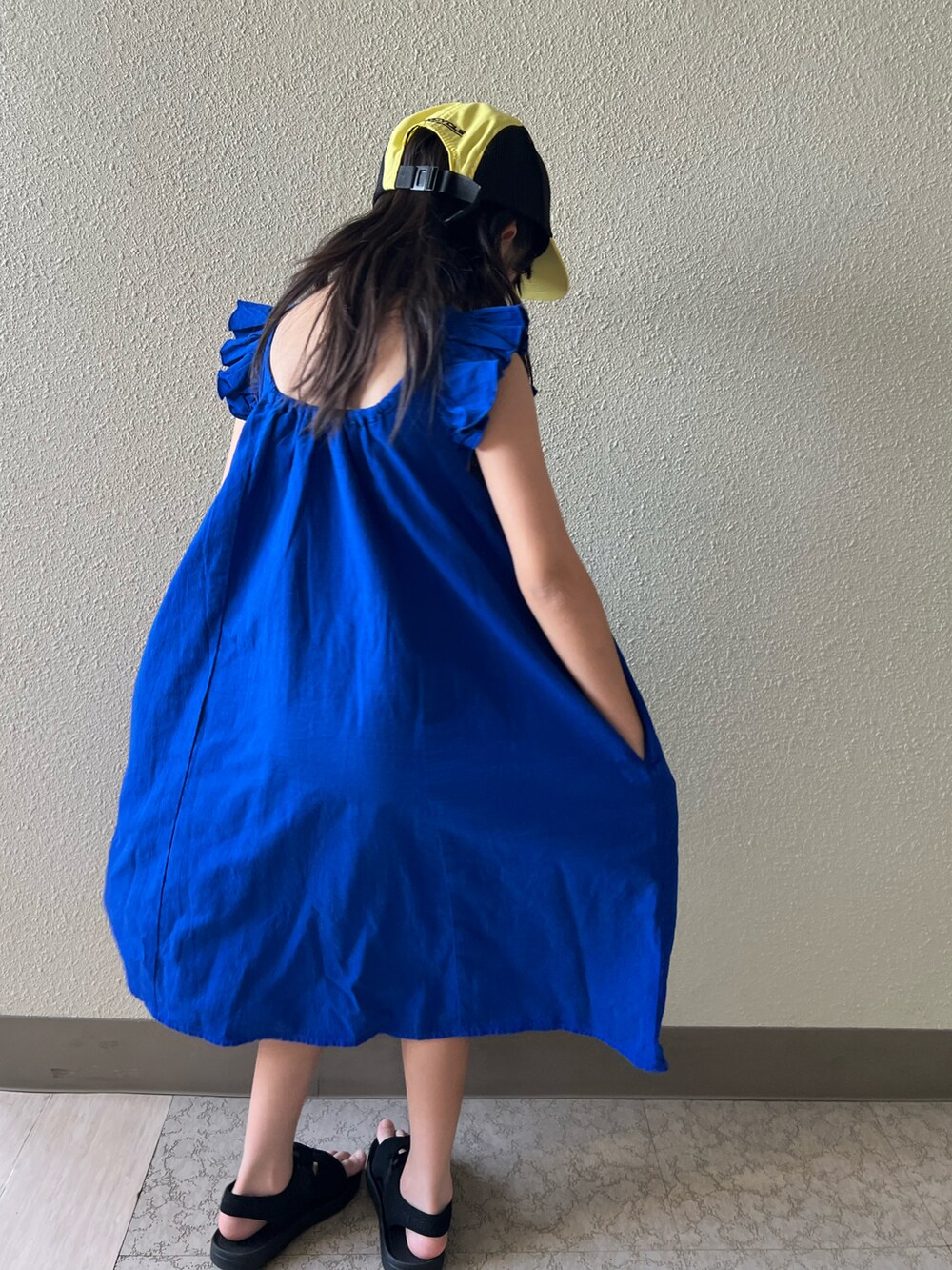 ブルー系のワンピース、ブラック系のサンダルを着用したキッズの夏コーディネートの3枚目の写真