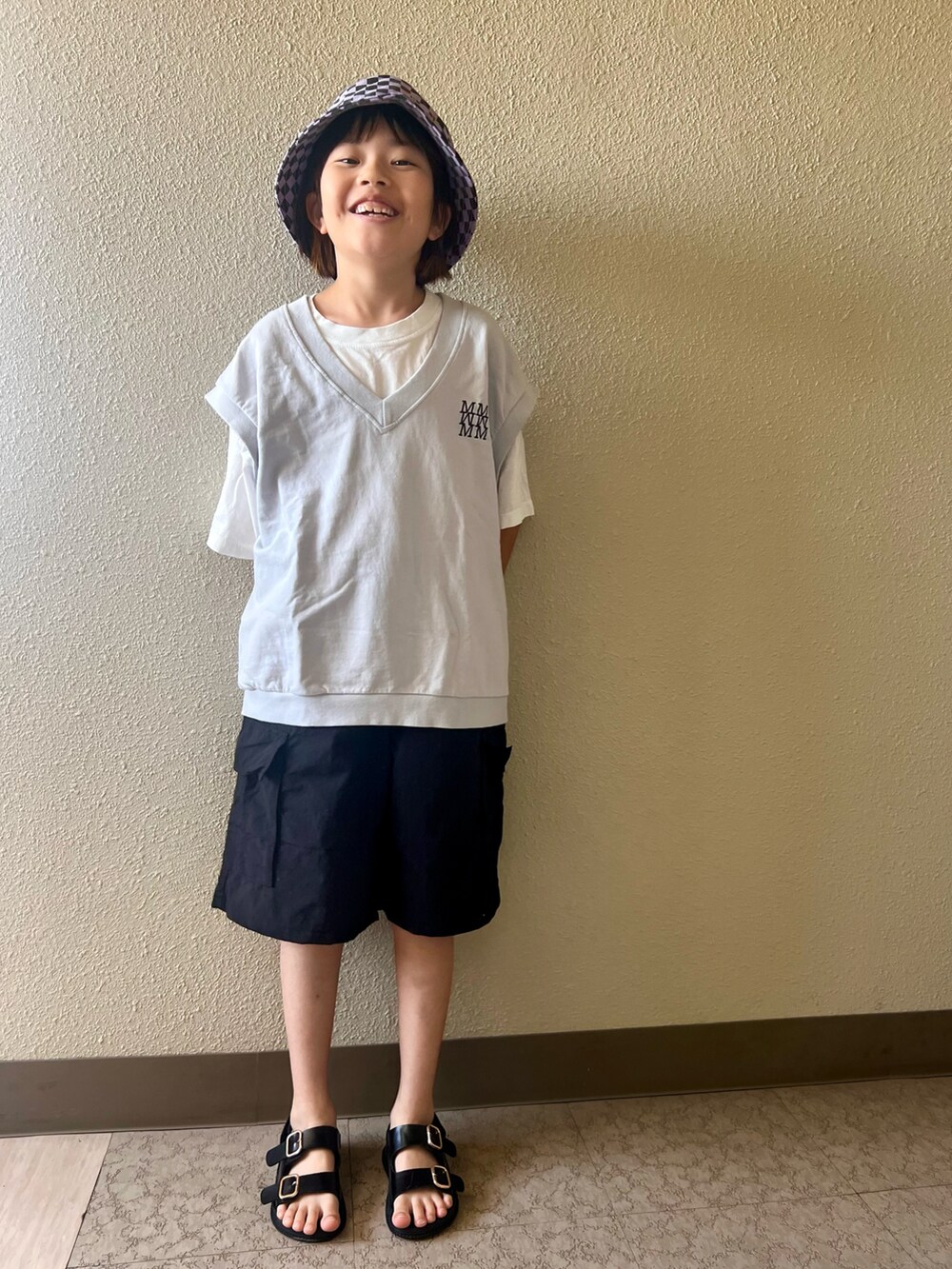 ブラック系のカーゴパンツ、グレー系のタンクトップ、パープル系の帽子を着用したキッズの春コーディネートの2枚目の写真