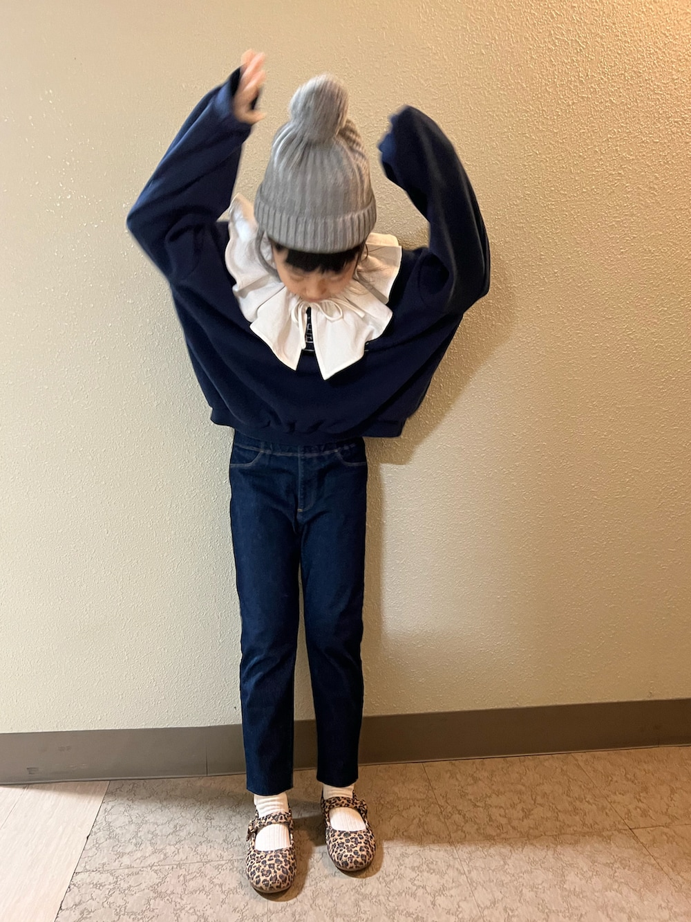 ブルー系のスウェット、ブルー系のデニムパンツ、ブラウン系のバレエシューズを着用したキッズの冬コーディネートの4枚目の写真