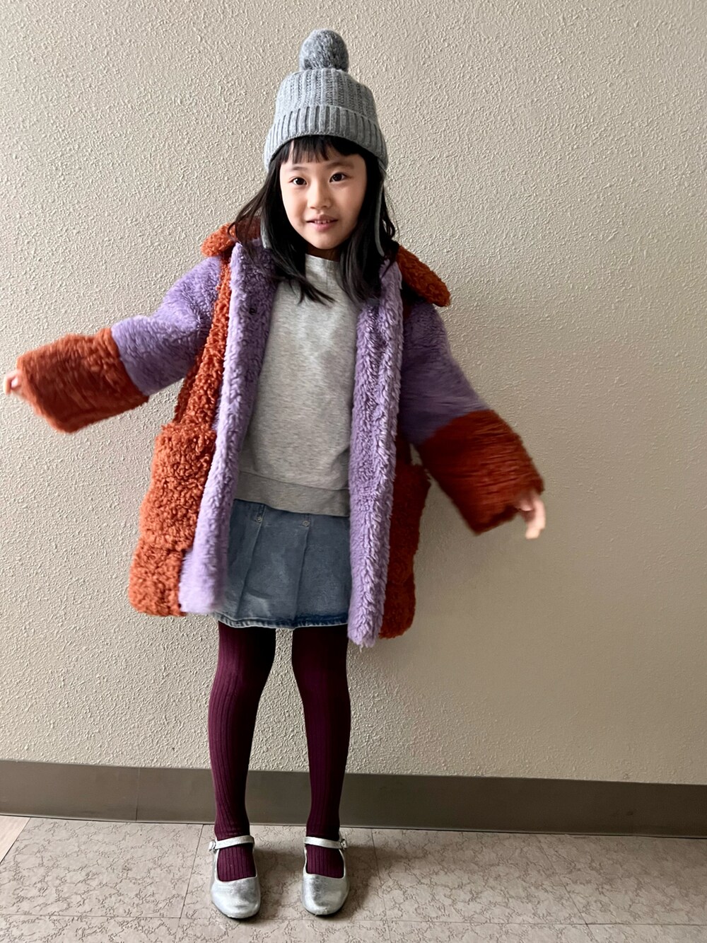 パープル系のジャケット/アウター、グレー系のスウェット、シルバー系のバレエシューズを着用したキッズの冬コーディネートの2枚目の写真