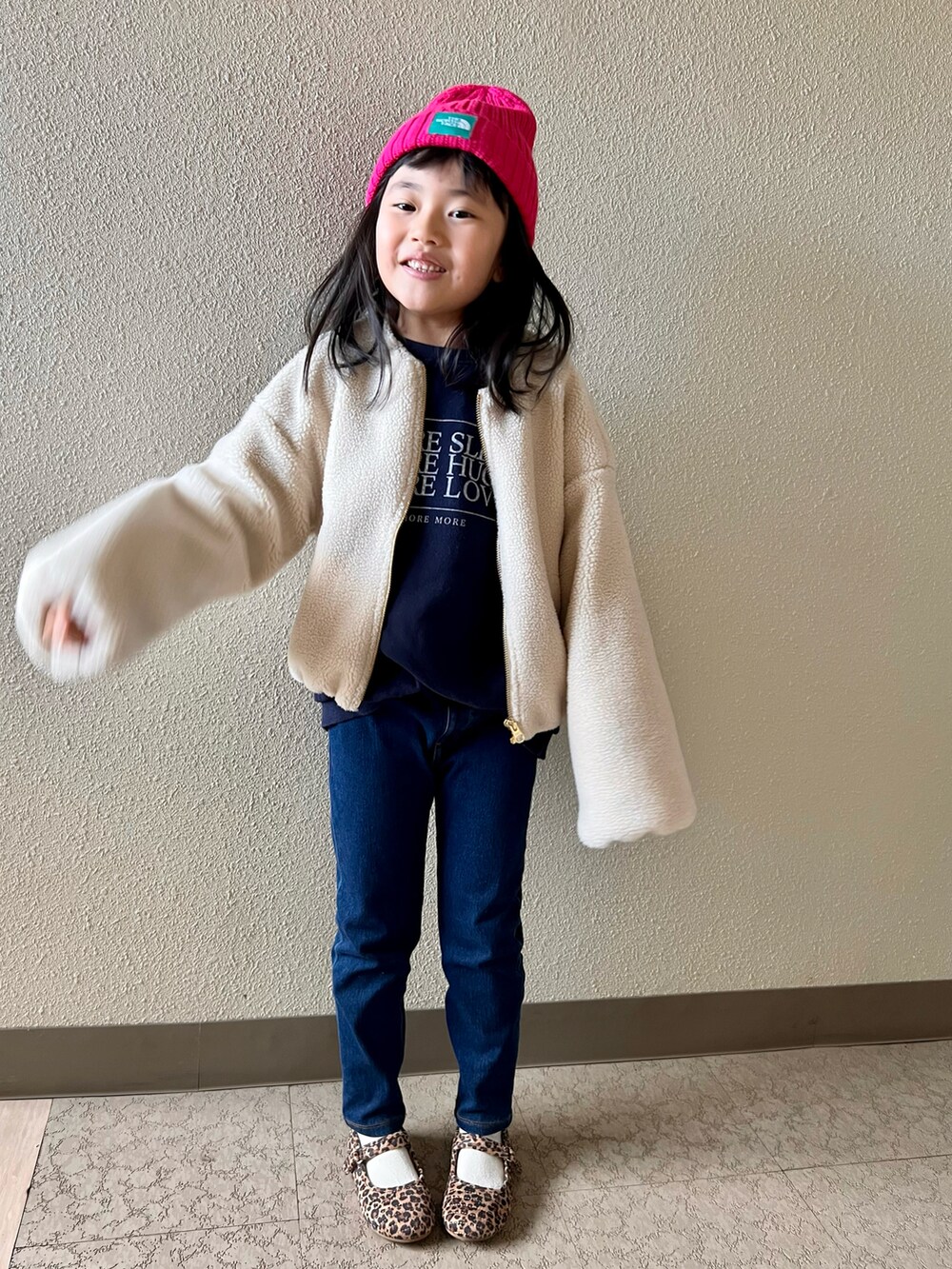 ブルー系のスウェット、ブルー系のデニムパンツ、ブラウン系のバレエシューズを着用したキッズの冬コーディネートの5枚目の写真