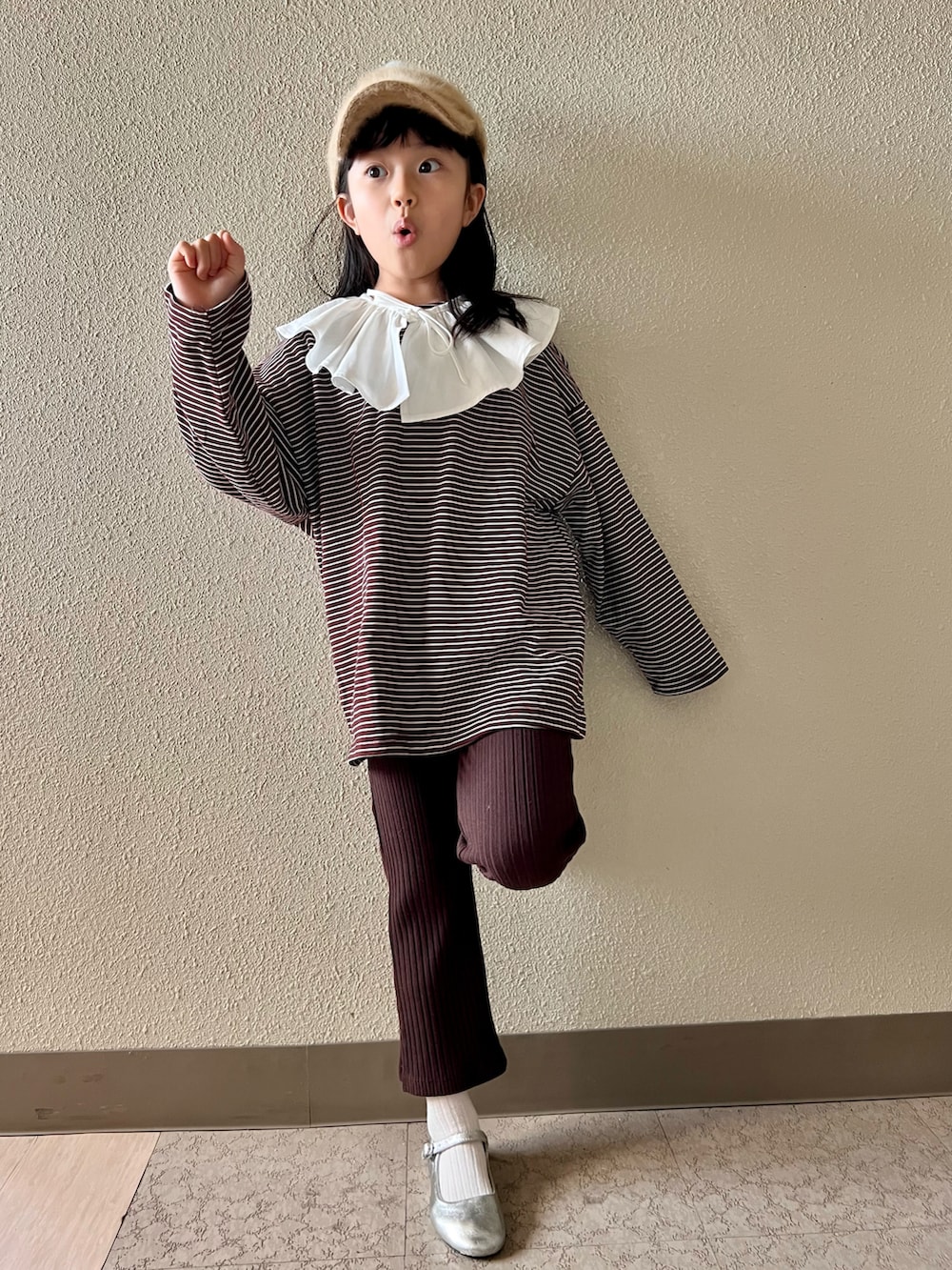 ブラウン系のTシャツ/カットソー、ブラウン系のパンツ、シルバー系のバレエシューズを着用したキッズの冬コーディネートの3枚目の写真