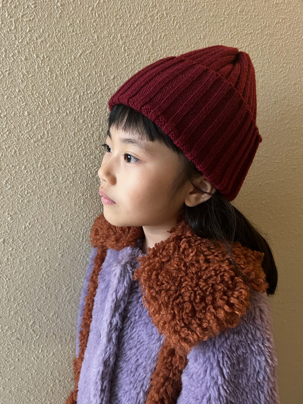 パープル系のジャケット/アウター、ブルー系のデニムパンツ、ブラック系のブーツを着用したキッズの冬コーディネートの5枚目の写真