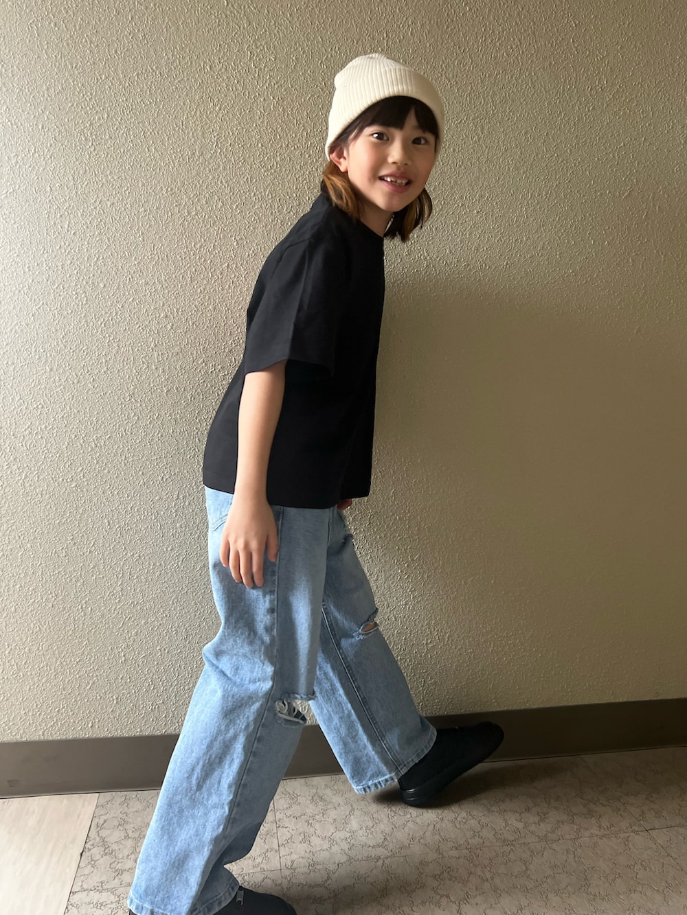 ブラック系のTシャツ/カットソー、ブラック系のスニーカー、ブルー系のデニムパンツを着用したキッズの春コーディネートの2枚目の写真