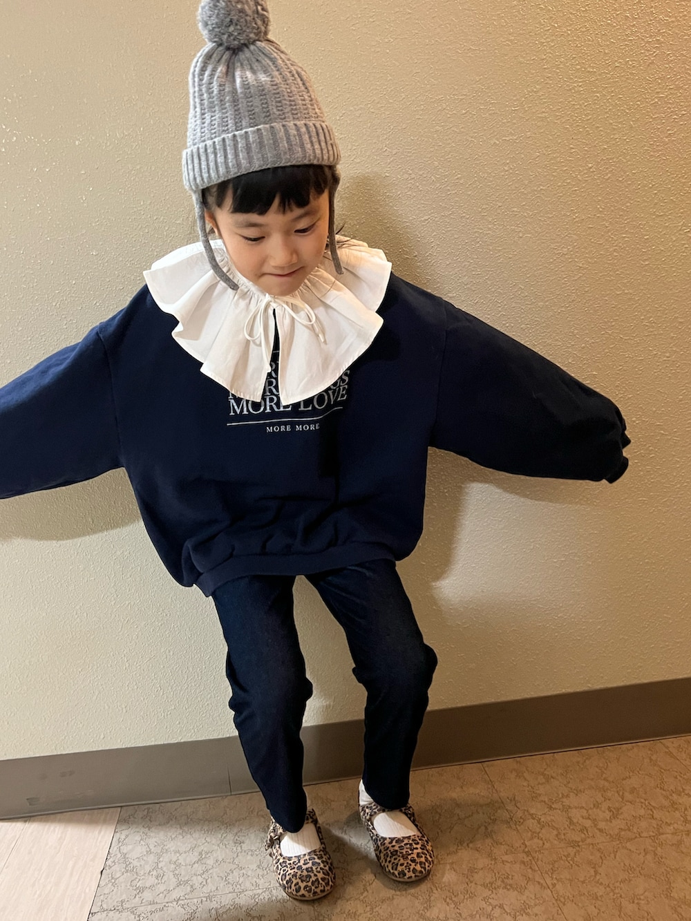 ブルー系のスウェット、ブルー系のデニムパンツ、ブラウン系のバレエシューズを着用したキッズの冬コーディネートの3枚目の写真