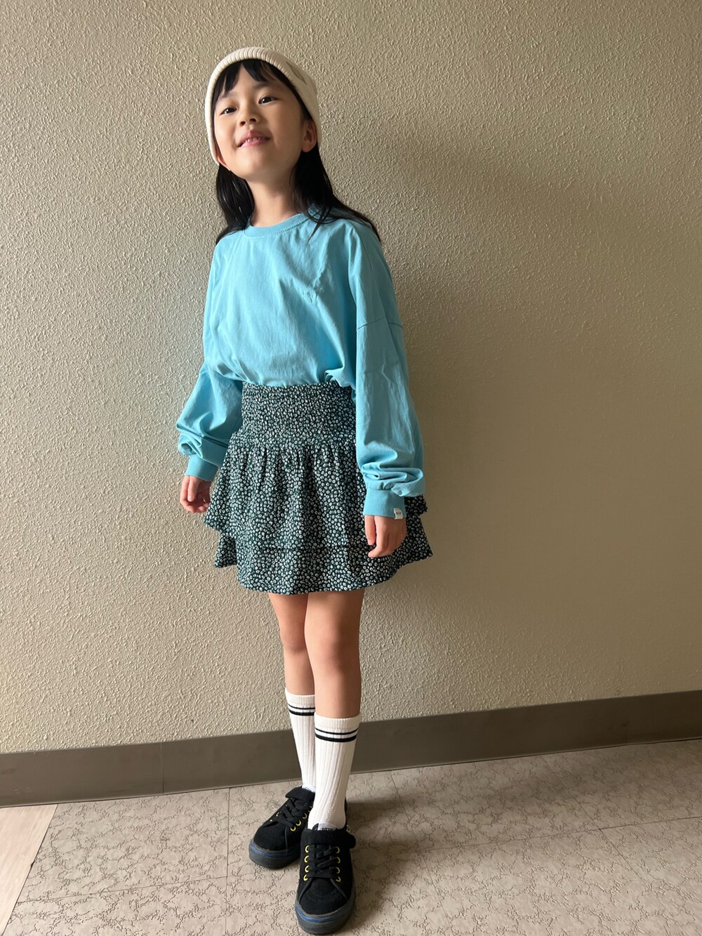 ブルー系のTシャツ/カットソー、グリーン系のスカート、ブラック系のスニーカーを着用したキッズの春コーディネートの2枚目の写真