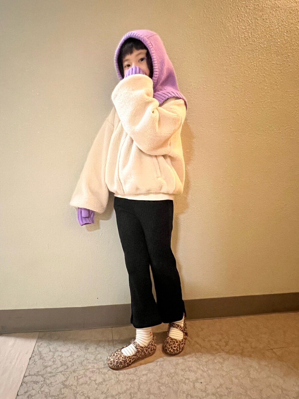 ホワイト系のブルゾン、ブラック系のその他パンツ、ブラウン系のバレエシューズを着用したキッズの冬コーディネートの2枚目の写真