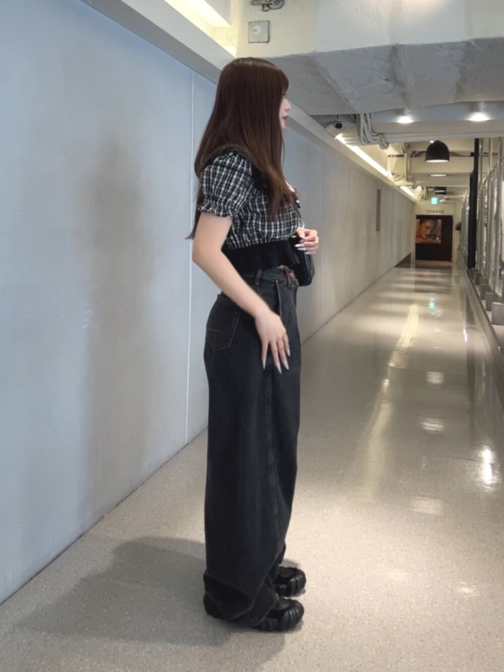 ブラック系のハンドバッグ、ブラック系のデニムパンツ、ブラック系のシャツ/ブラウスを着用したレディースの春コーディネートの2枚目の写真