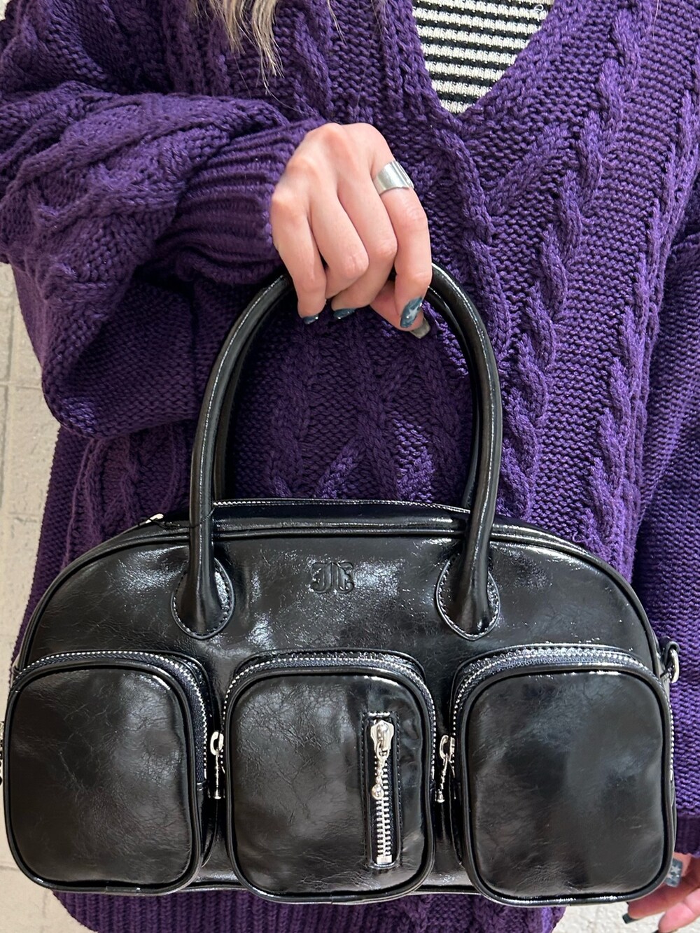 ブラック系のボストンバッグ、ブラック系のブーツ、パープル系のニット/セーターを着用したレディースの秋コーディネートの7枚目の写真