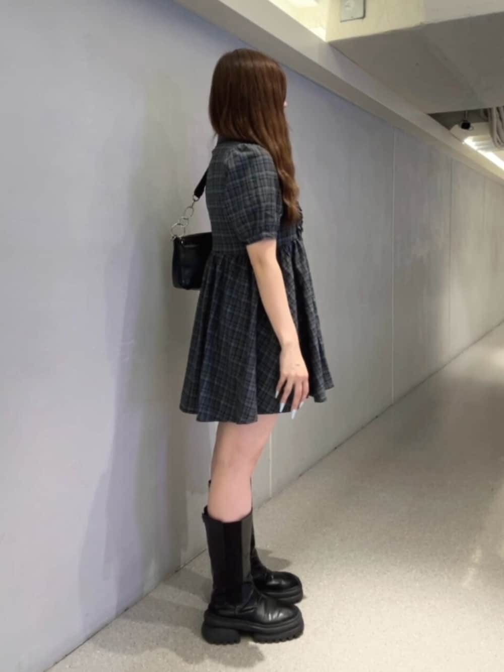 ブラック系のハンドバッグ、ブルー系のワンピースを着用したレディースの夏コーディネートの2枚目の写真
