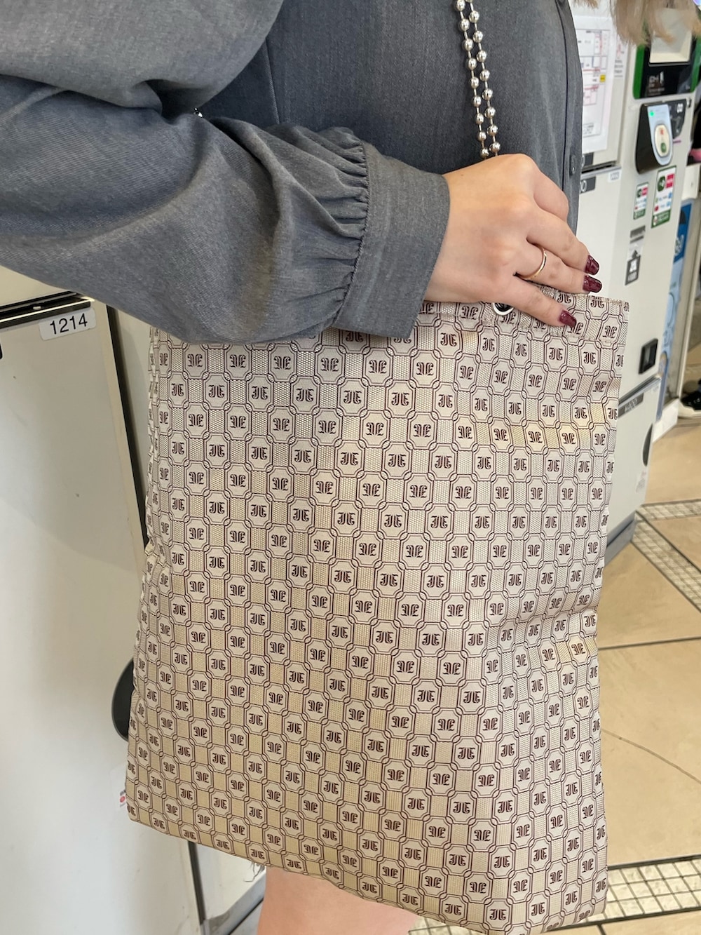 ベージュ系のトートバッグ、グレー系のワンピース、ブラック系のブーツを着用したレディースの冬コーディネートの6枚目の写真