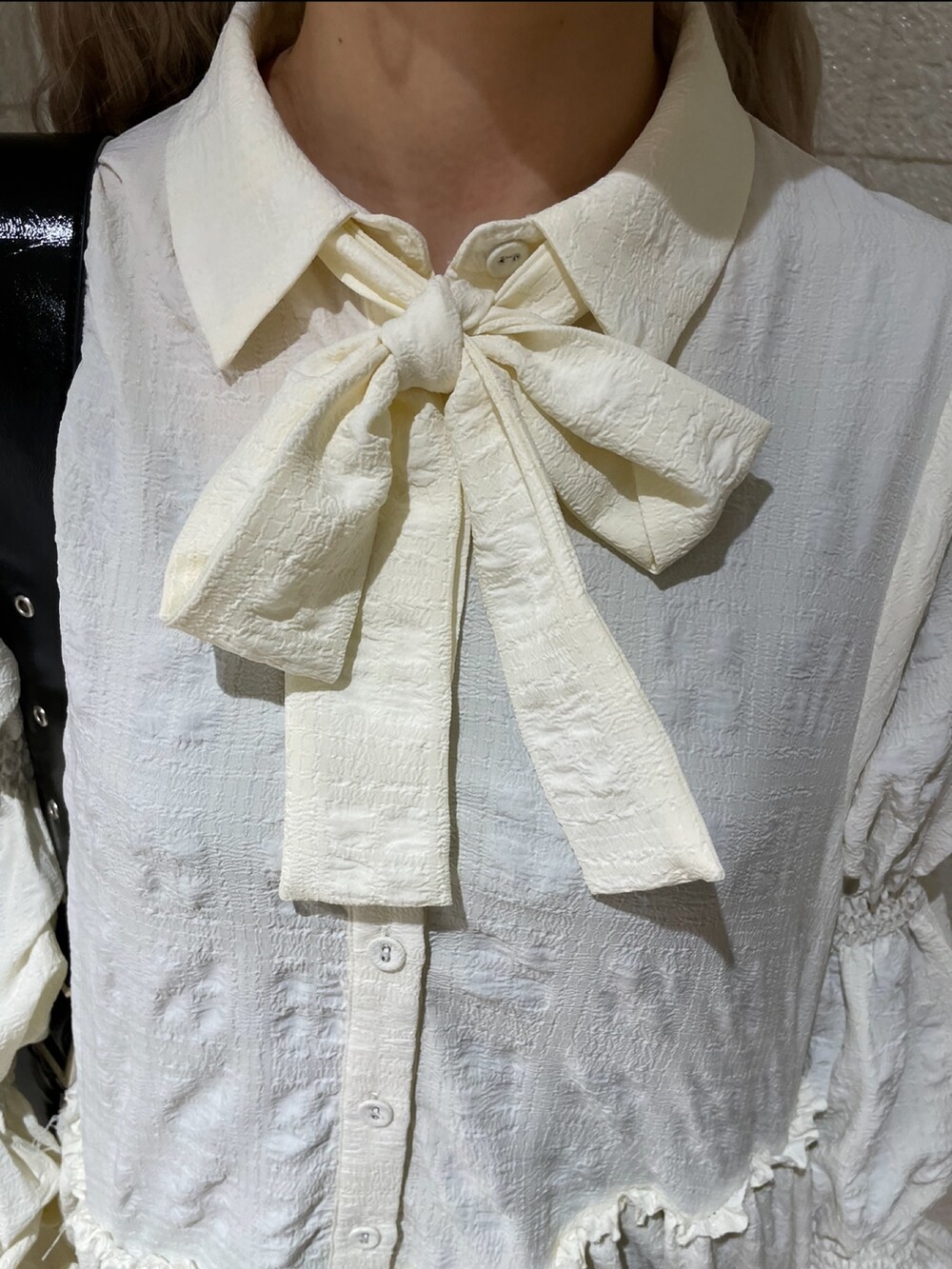 ブラック系のデニムパンツ、ホワイト系のシャツ/ブラウス、ブラック系のブーツを着用したレディースの冬コーディネートの6枚目の写真