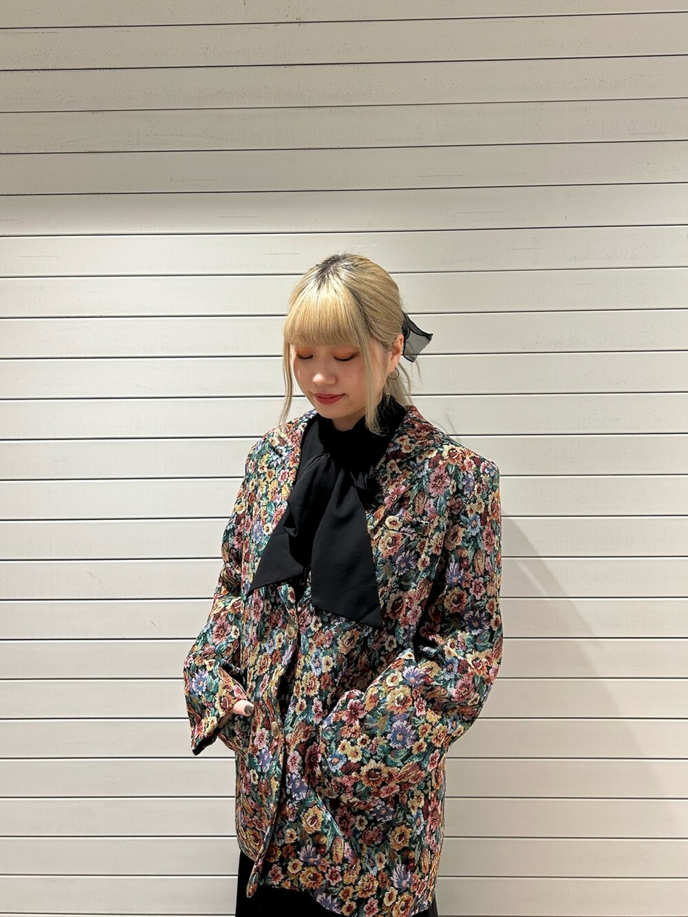 ブラック系のテーラードジャケット、ブラック系のワンピースを着用したレディースの冬コーディネートの4枚目の写真