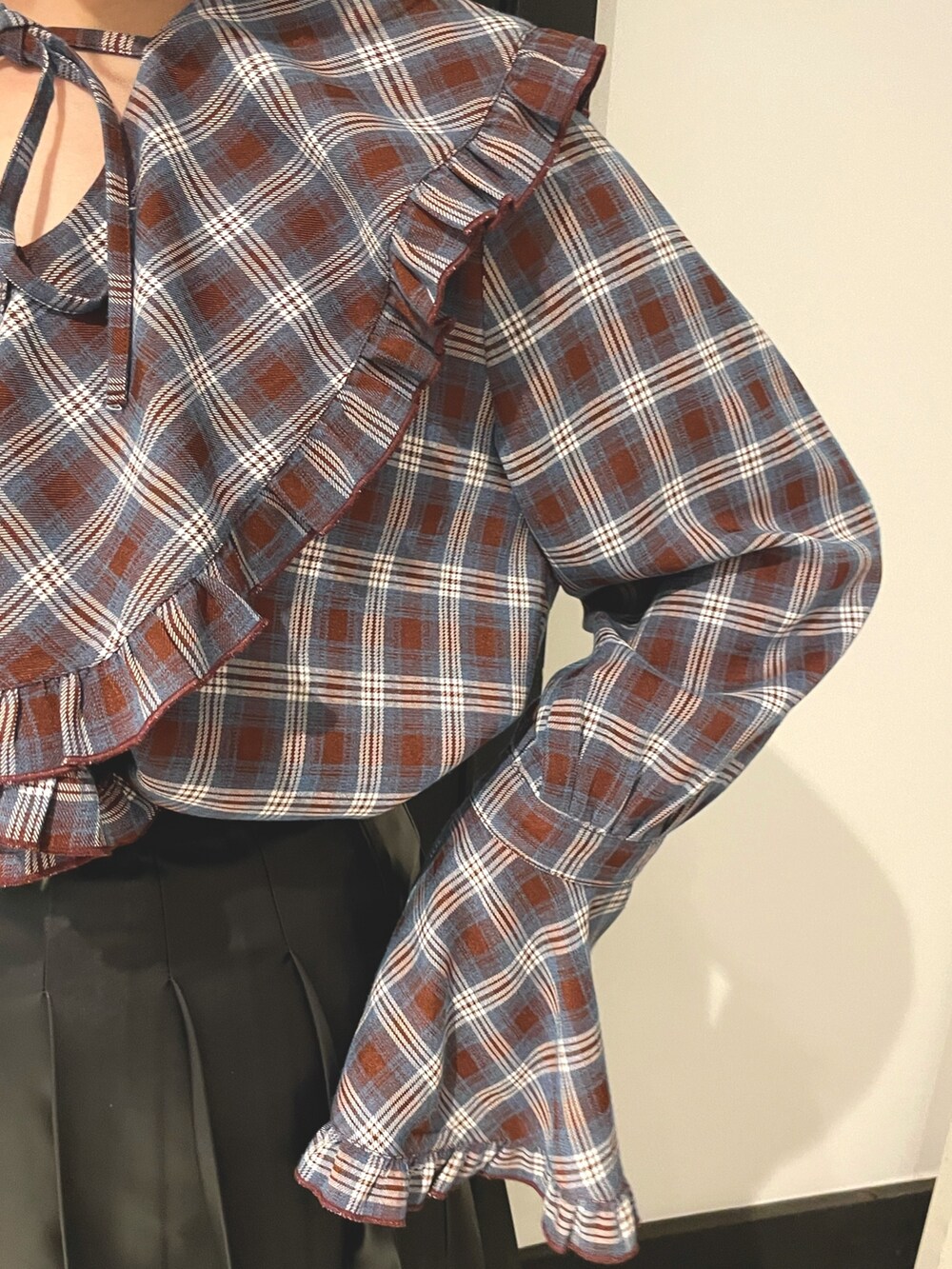 ブラウン系のシャツ/ブラウス、ブラック系のスカート、ブラック系のブーツを着用したレディースの秋コーディネートの5枚目の写真