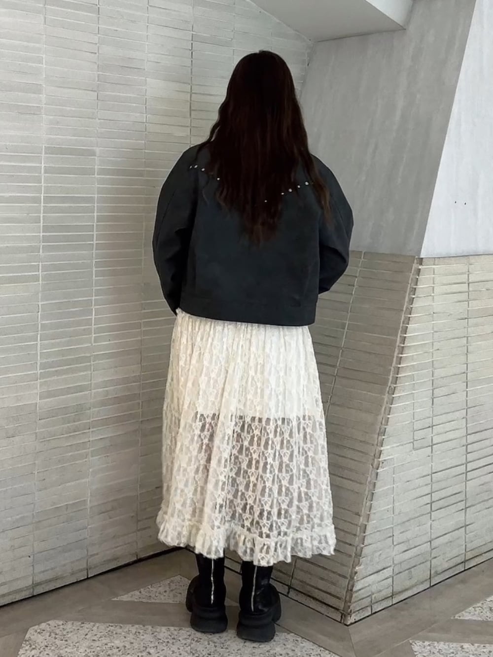 ホワイト系のワンピース、ブラック系のブルゾンを着用したレディースの冬コーディネートの3枚目の写真