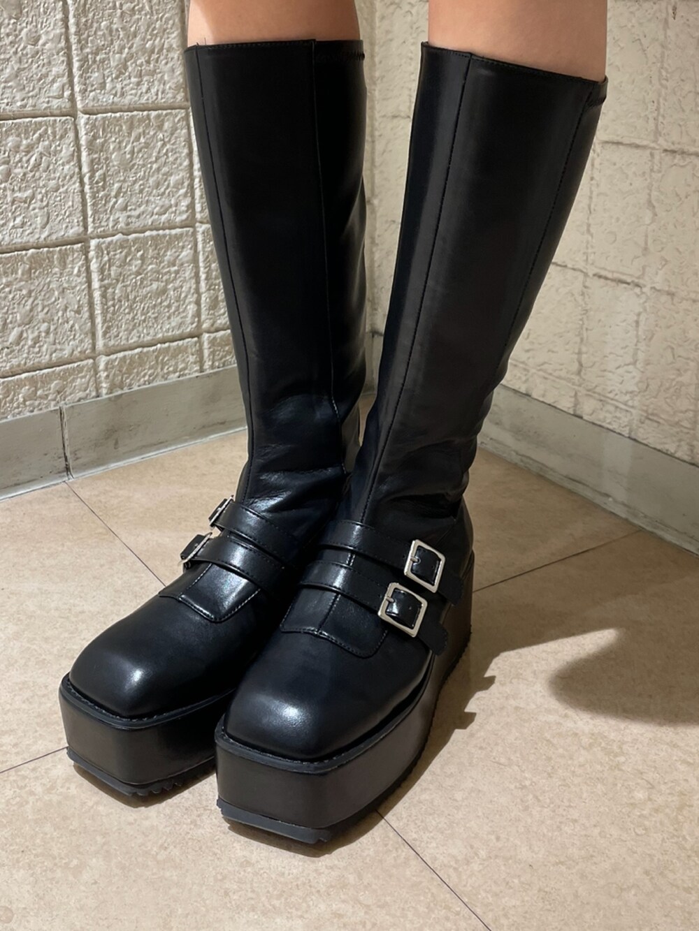 ブラック系のデニムパンツ、ホワイト系のシャツ/ブラウス、ブラック系のブーツを着用したレディースの冬コーディネートの8枚目の写真