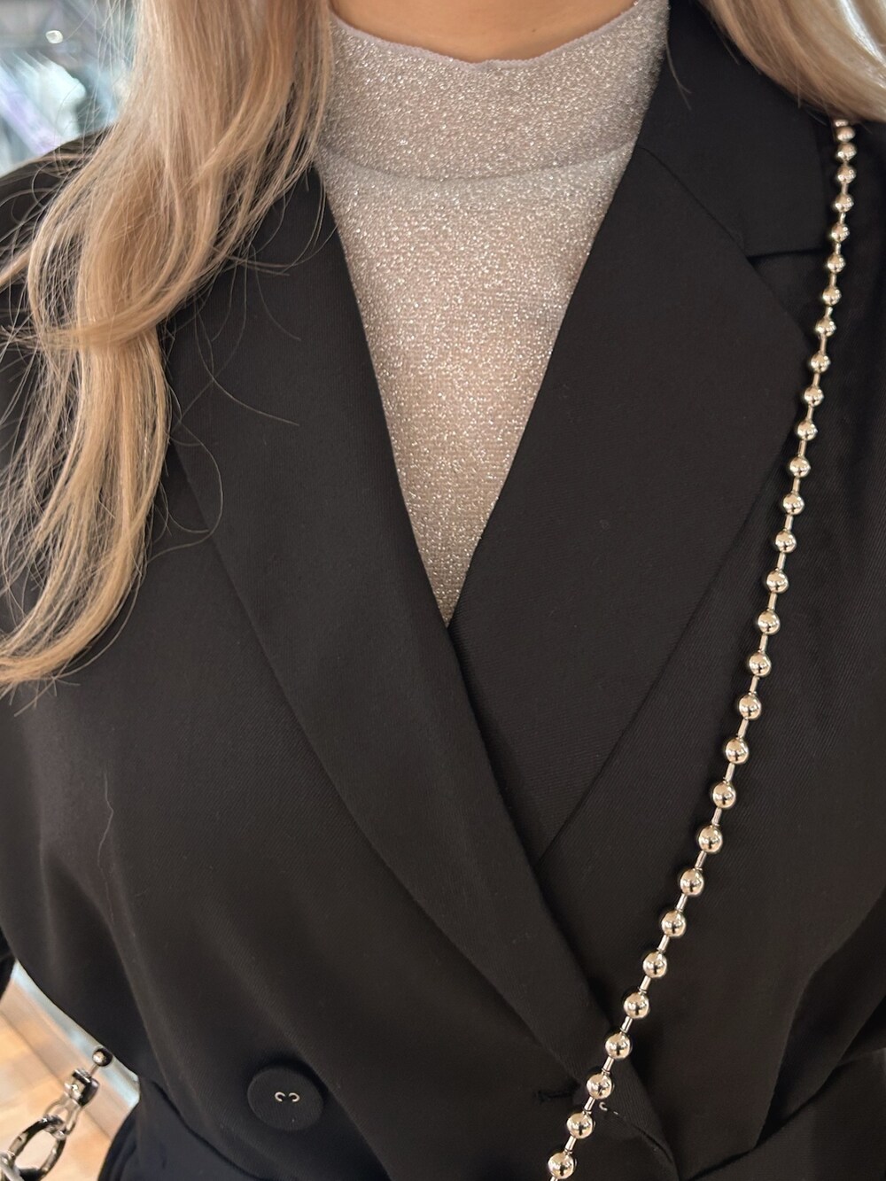 ブラック系のワンピース、シルバー系のTシャツ/カットソー、ホワイト系のショルダーバッグを着用したレディースの秋コーディネートの4枚目の写真