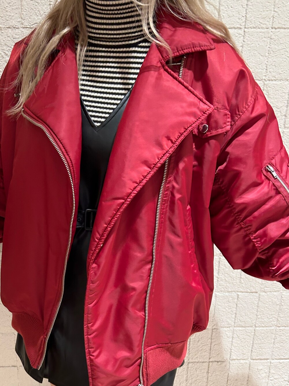 レッド系のMA-1、ブラック系のブーツ、ブラック系のジャンパースカートを着用したレディースの冬コーディネートの8枚目の写真