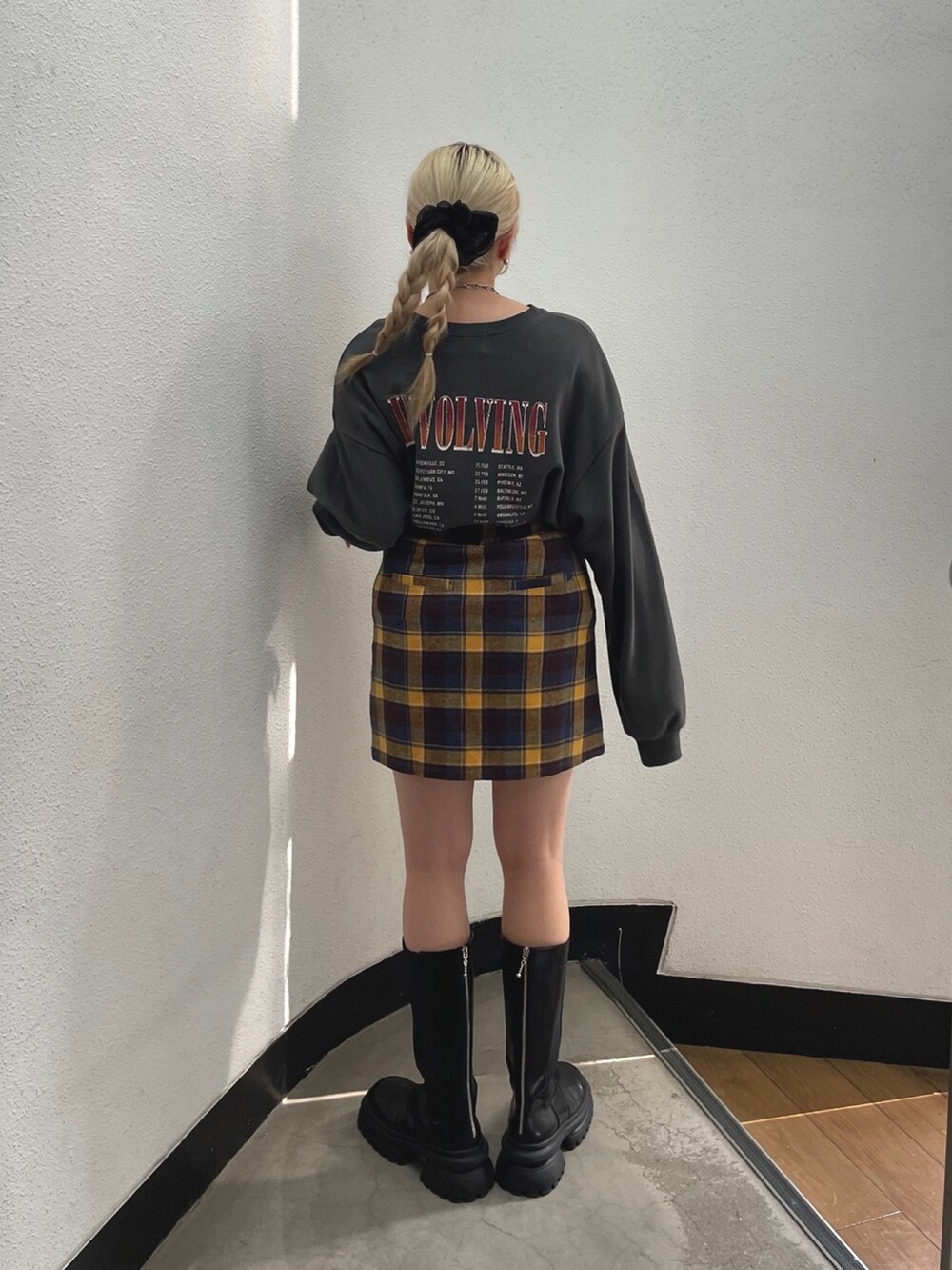 ブラック系のスウェット、イエロー系のスカートを着用したレディースの夏コーディネートの3枚目の写真