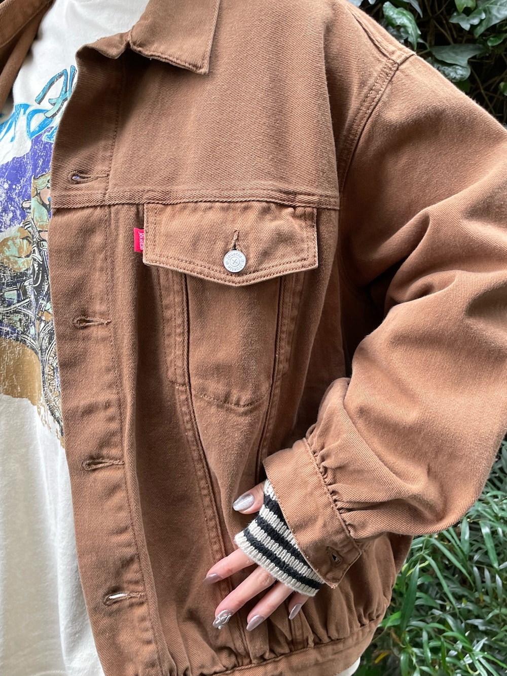 ブラウン系のデニムジャケット、ホワイト系のTシャツ/カットソー、ブラック系のその他シューズを着用したレディースの冬コーディネートの6枚目の写真