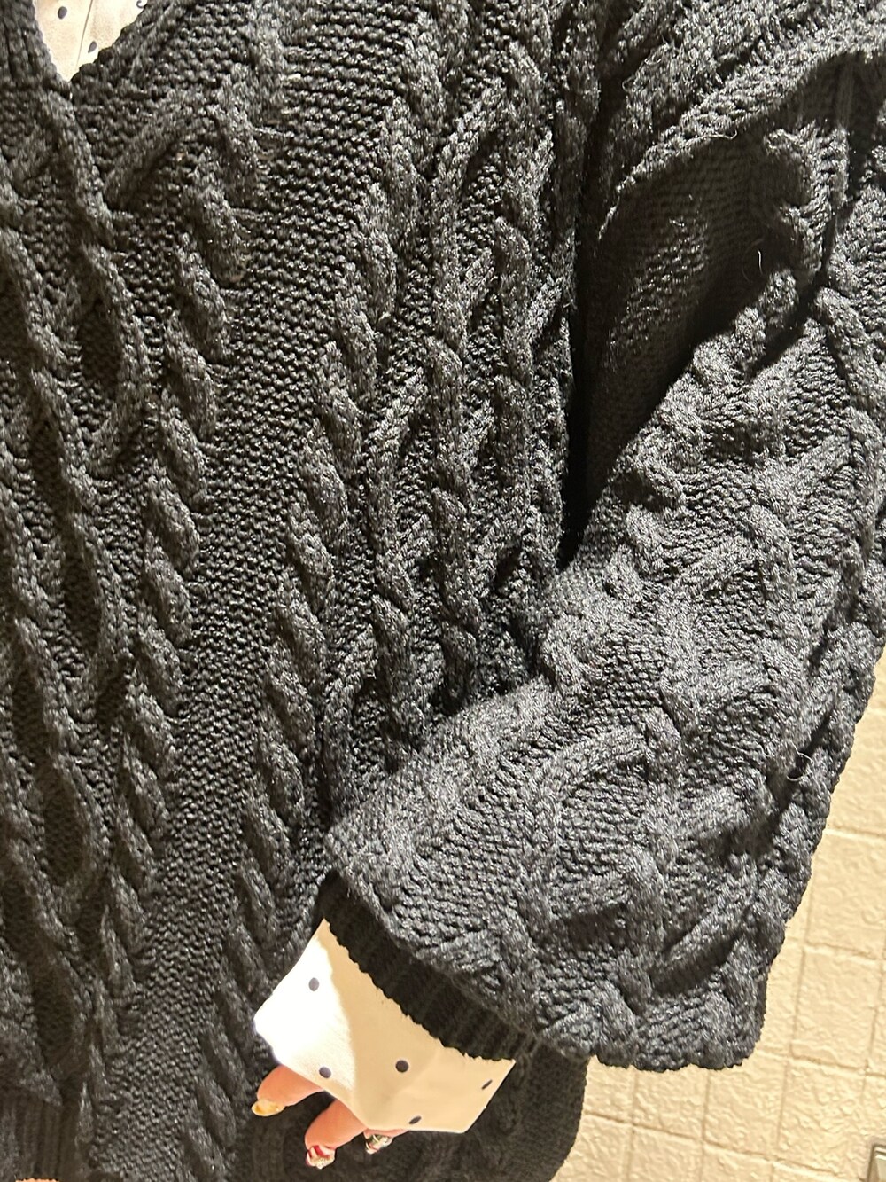 ブラック系のニット/セーター、ブラック系のブーツ、ホワイト系のシャツ/ブラウスを着用したレディースの冬コーディネートの7枚目の写真