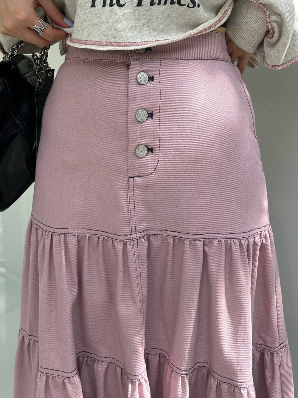 ピンク系のワンピース、ブラック系のハンドバッグ、グレー系のスウェットを着用したレディースの冬コーディネートの6枚目の写真