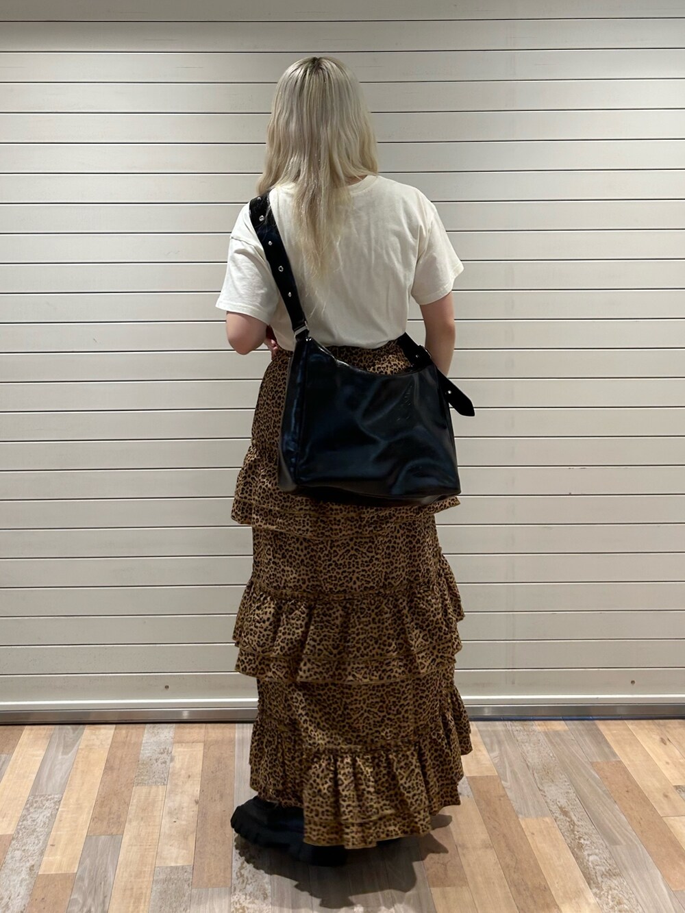 ブラウン系のスカート、ホワイト系のTシャツ/カットソー、ブラック系のショルダーバッグを着用したレディースの春コーディネートの3枚目の写真