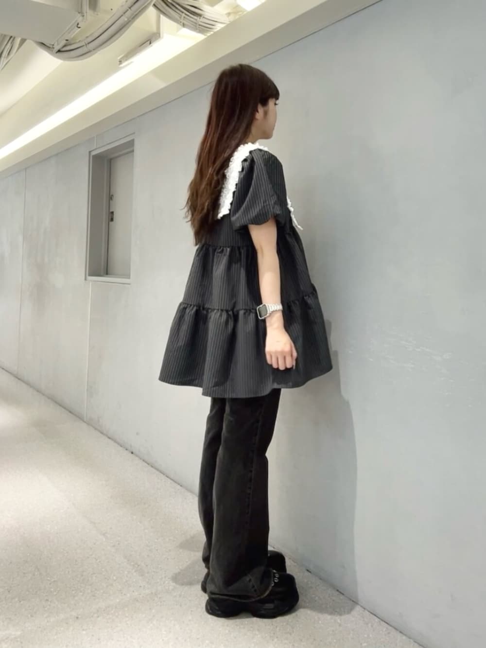 グレー系のワンピース、ブラック系のデニムパンツ、ブラック系のパンプスを着用したレディースの夏コーディネートの2枚目の写真