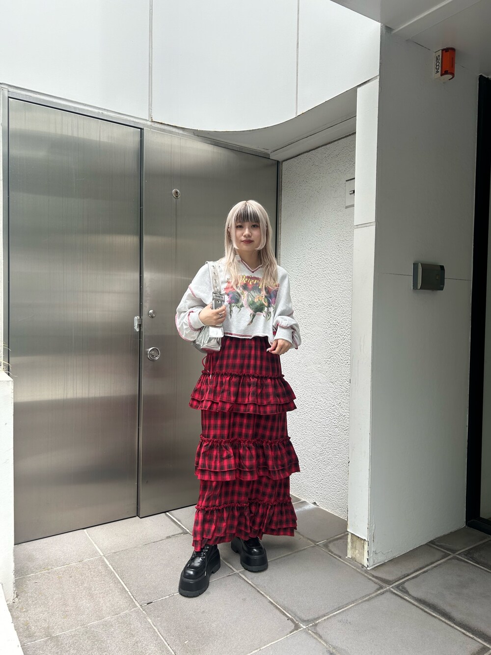 ホワイト系のシャツ/ブラウス、レッド系のカーディガン/ボレロ、ブラック系のハンドバッグを着用したレディースの夏コーディネートの9枚目の写真