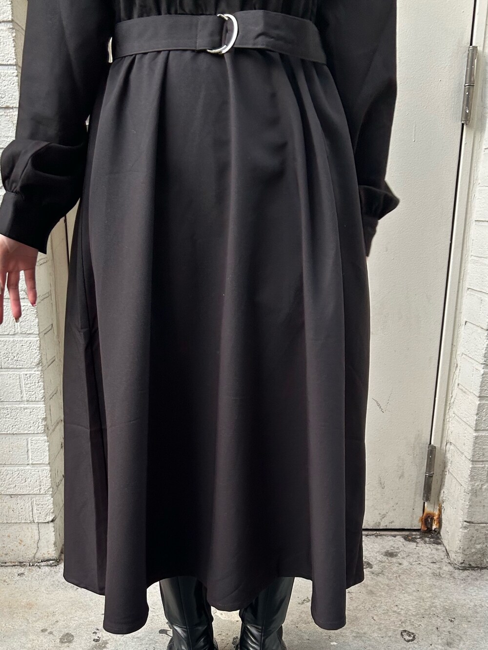 ブラック系のワンピース、ブラック系のブーツを着用したレディースの冬コーディネートの7枚目の写真