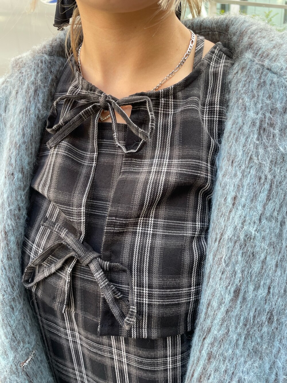 ブルー系のチェスターコート、ブラック系のワンピース、ブラック系のその他シューズを着用したレディースの冬コーディネートの5枚目の写真