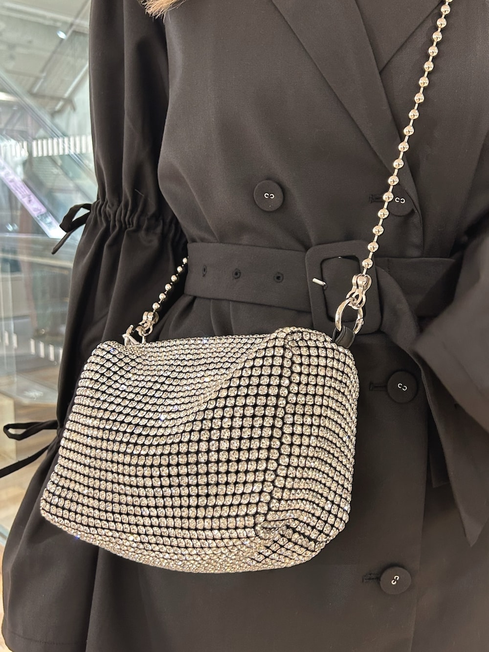 ブラック系のワンピース、シルバー系のTシャツ/カットソー、ホワイト系のショルダーバッグを着用したレディースの秋コーディネートの7枚目の写真