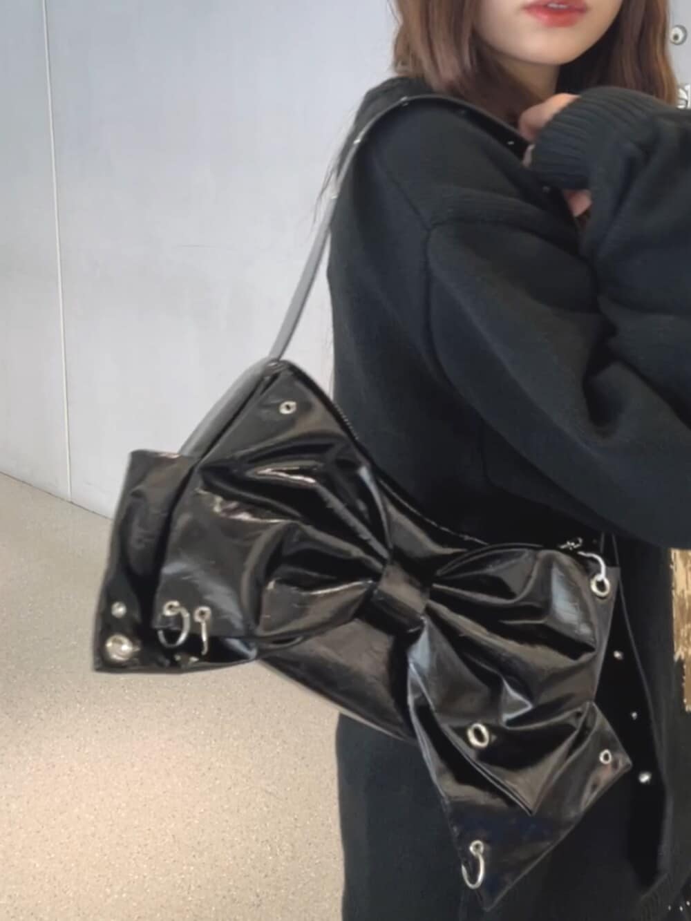 ブラック系のブーツ、ブラック系のスカート、ブラック系のショルダーバッグを着用したレディースの秋コーディネートの5枚目の写真