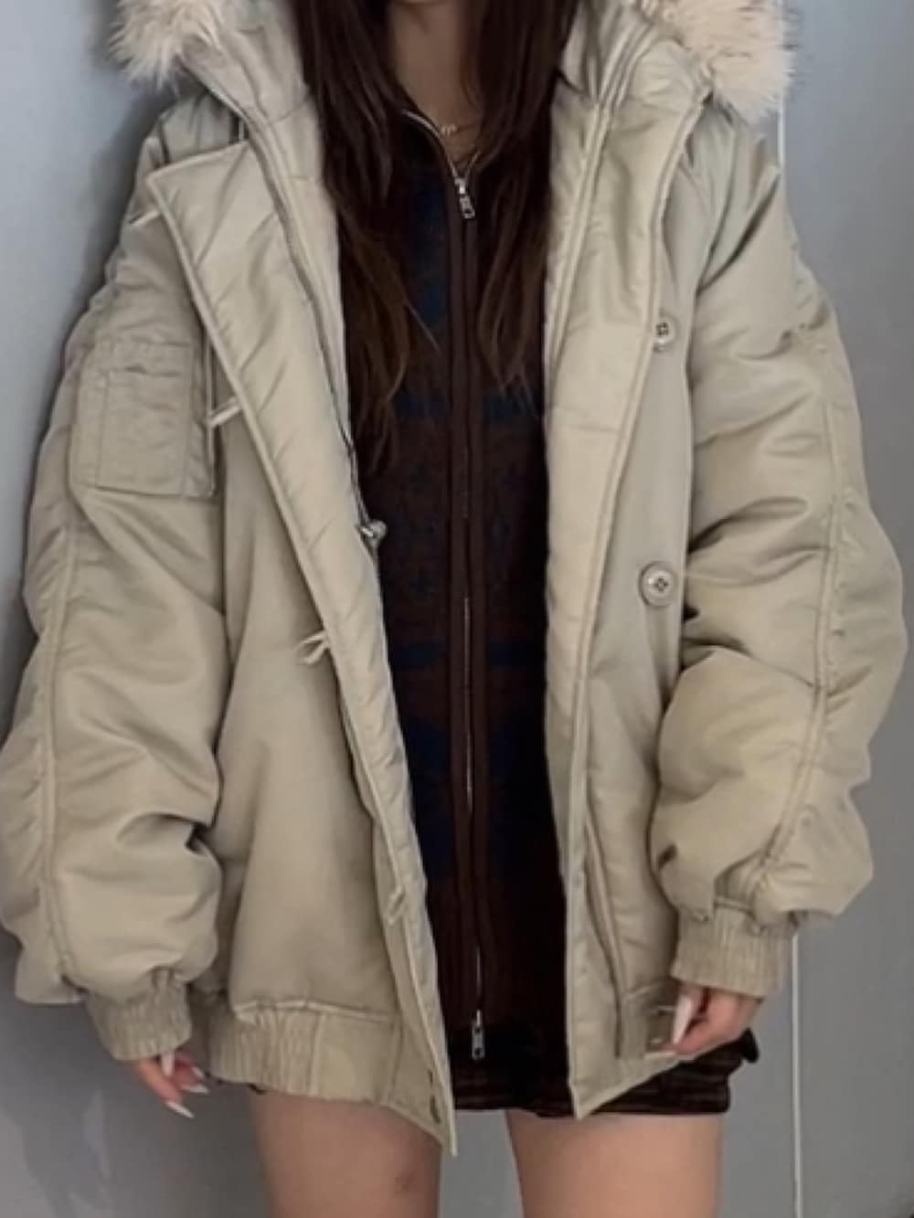 ホワイト系のブルゾン、ブラウン系のカーディガン/ボレロ、ブルー系のブーツを着用したレディースの秋コーディネートの4枚目の写真