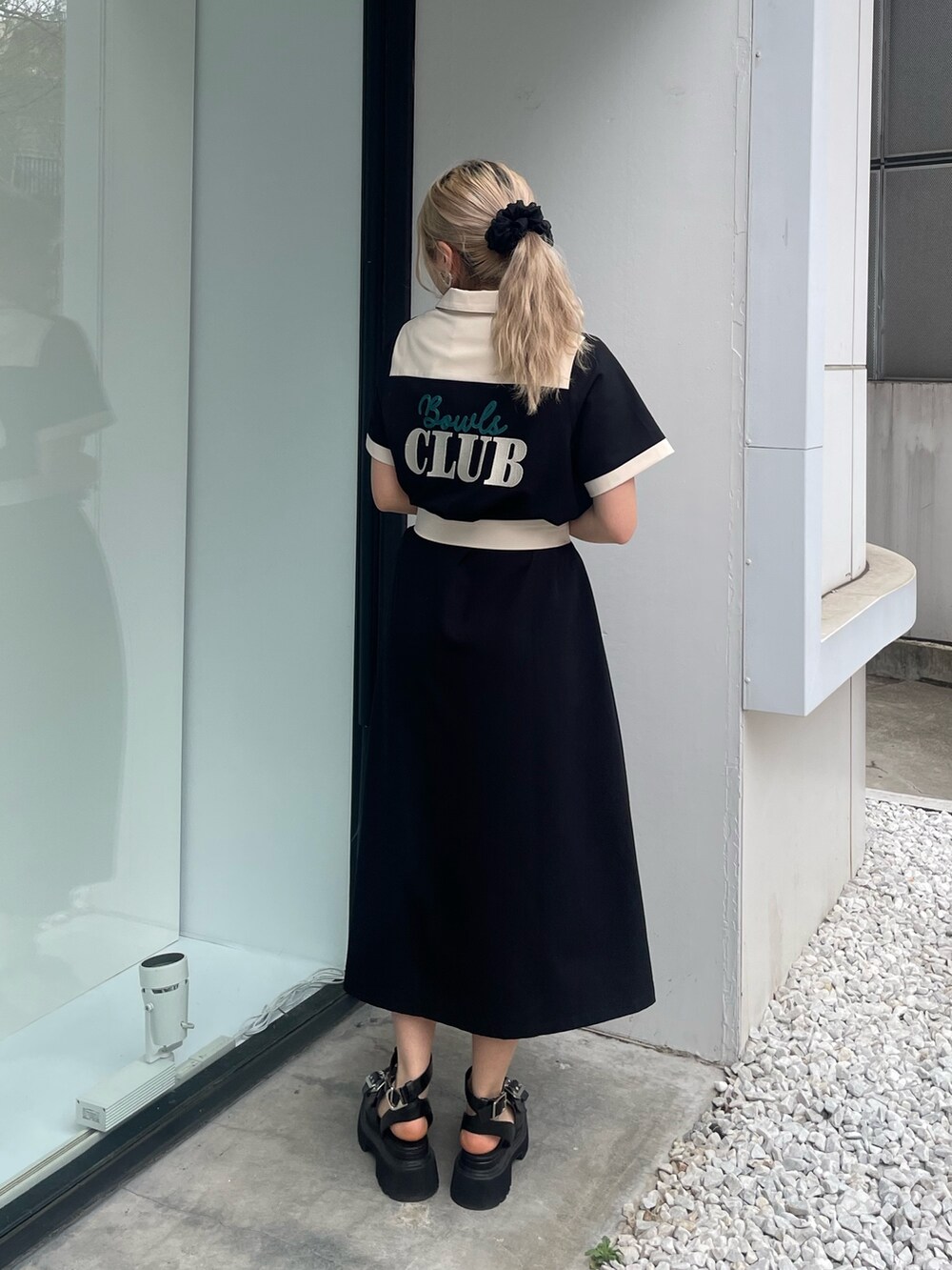 ブラック系のワンピース、ブラック系のサンダル、シルバー系のピアス（両耳用）を着用したレディースの春コーディネートの2枚目の写真