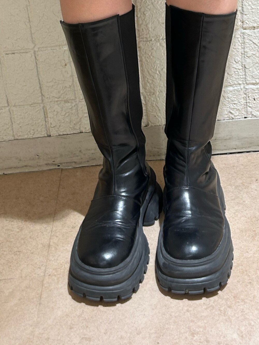 ブラック系のボストンバッグ、ブラック系のブーツ、パープル系のニット/セーターを着用したレディースの秋コーディネートの8枚目の写真