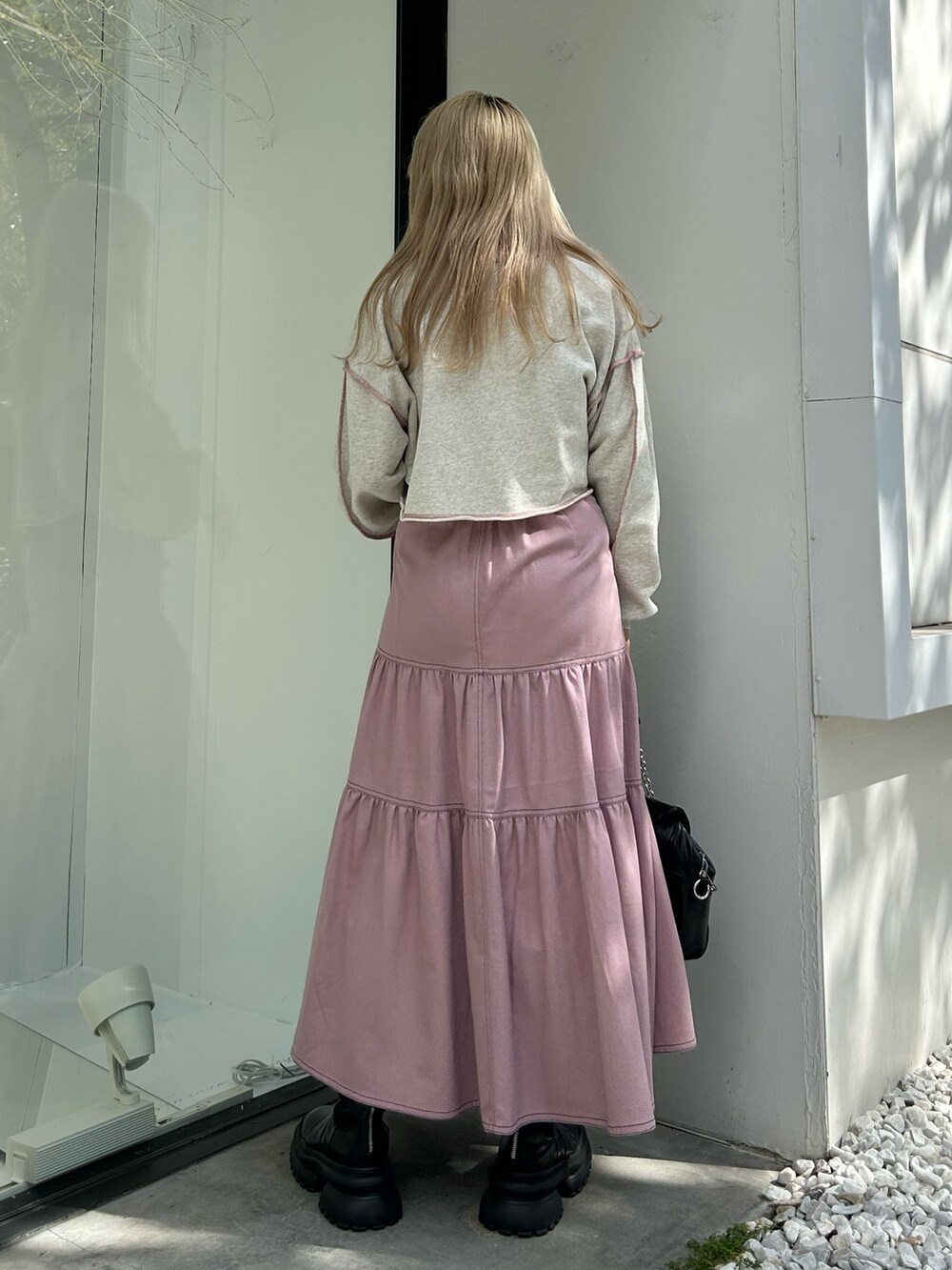 ピンク系のワンピース、ブラック系のハンドバッグ、グレー系のスウェットを着用したレディースの冬コーディネートの3枚目の写真