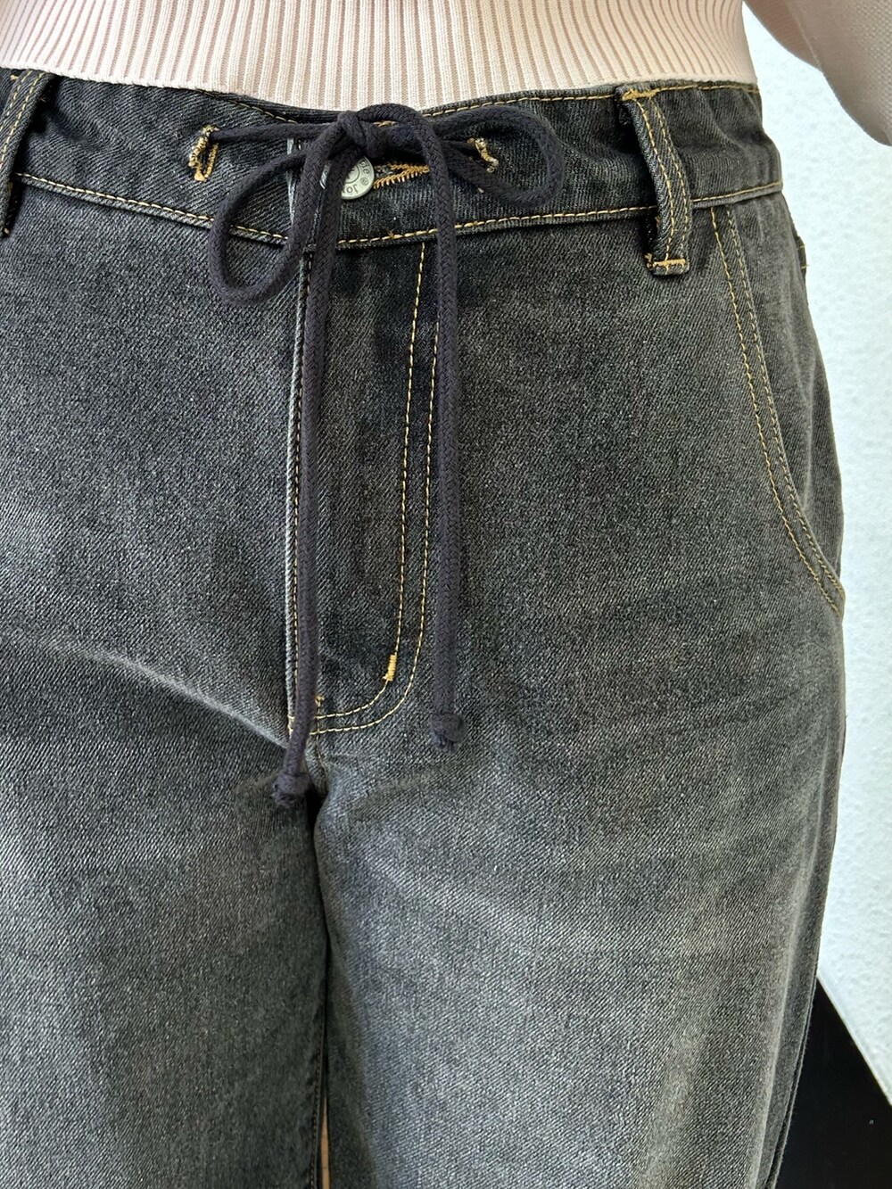 ピンク系のニット/セーター、ブラック系のデニムパンツ、ブラック系のその他シューズを着用したレディースの冬コーディネートの5枚目の写真