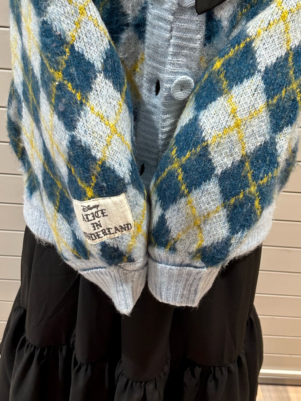 ブラック系のブーツ、ブルー系のカーディガン/ボレロ、ブラック系のワンピースを着用したレディースの秋コーディネートの8枚目の写真