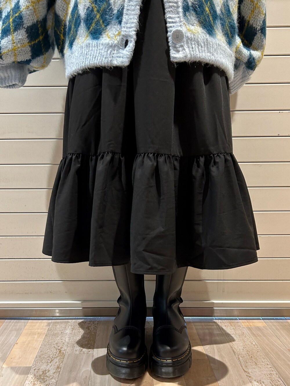 ブラック系のブーツ、ブルー系のカーディガン/ボレロ、ブラック系のワンピースを着用したレディースの秋コーディネートの9枚目の写真