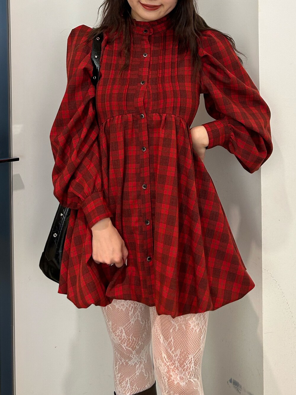 レッド系のワンピース、ブラウン系のブーツ、ブラック系のショルダーバッグを着用したレディースの夏コーディネートの5枚目の写真