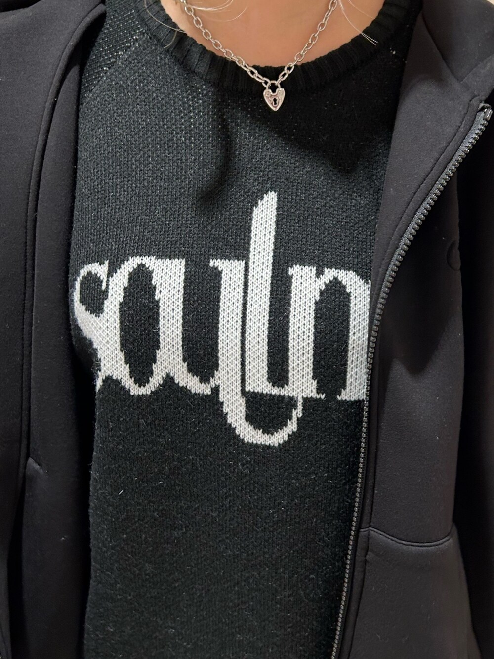 ブラック系のニット/セーター、ブラック系のブーツ、ブラック系のパーカーを着用したレディースの冬コーディネートの4枚目の写真