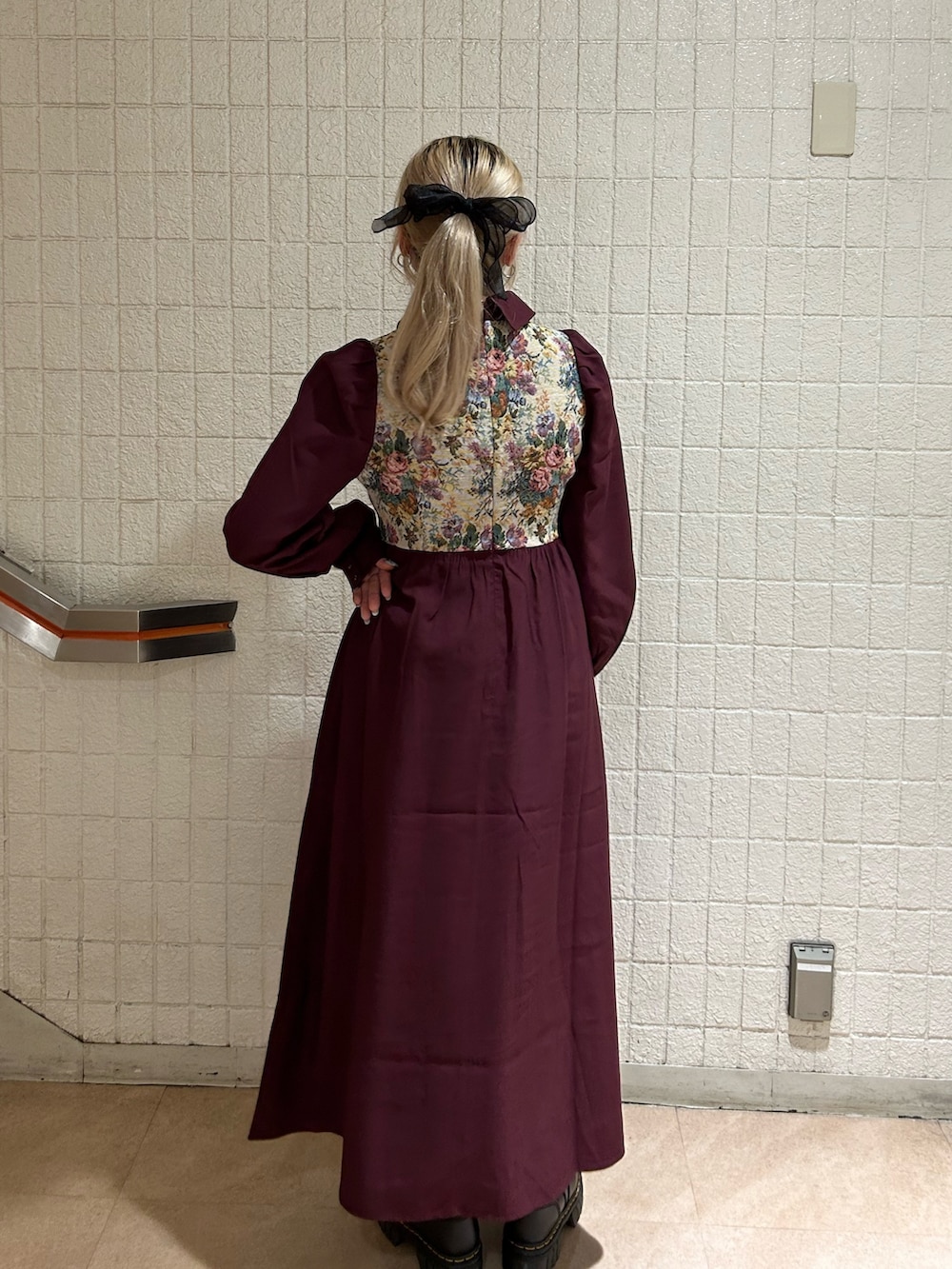 ブラック系のブーツ、レッド系のワンピースを着用したレディースの秋コーディネートの3枚目の写真