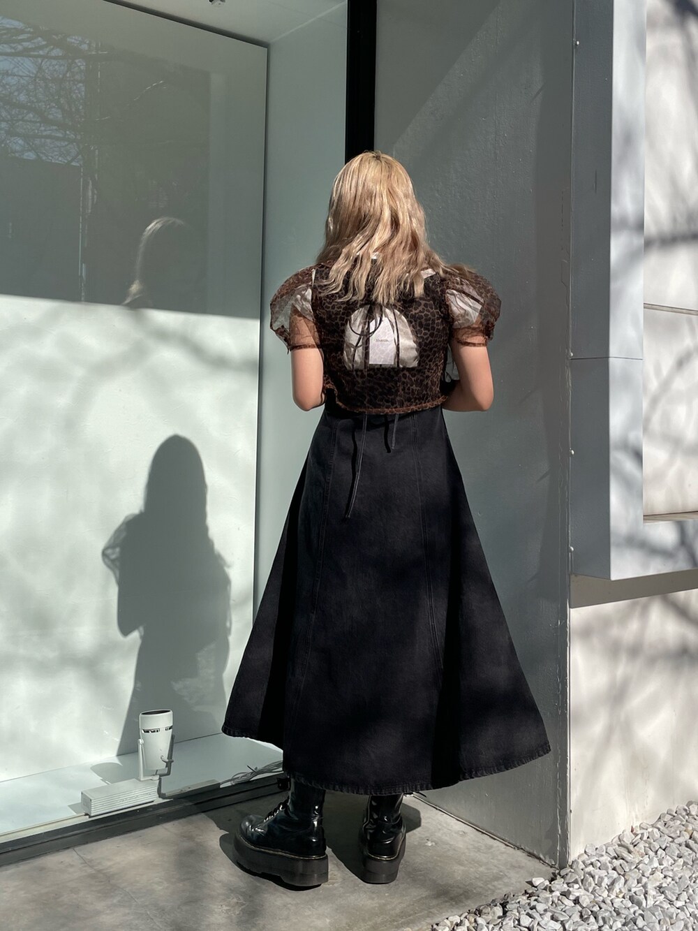 ブラック系のジャンパースカート、ホワイト系のタンクトップ、ブラウン系のシャツ/ブラウスを着用したレディースの春コーディネートの4枚目の写真