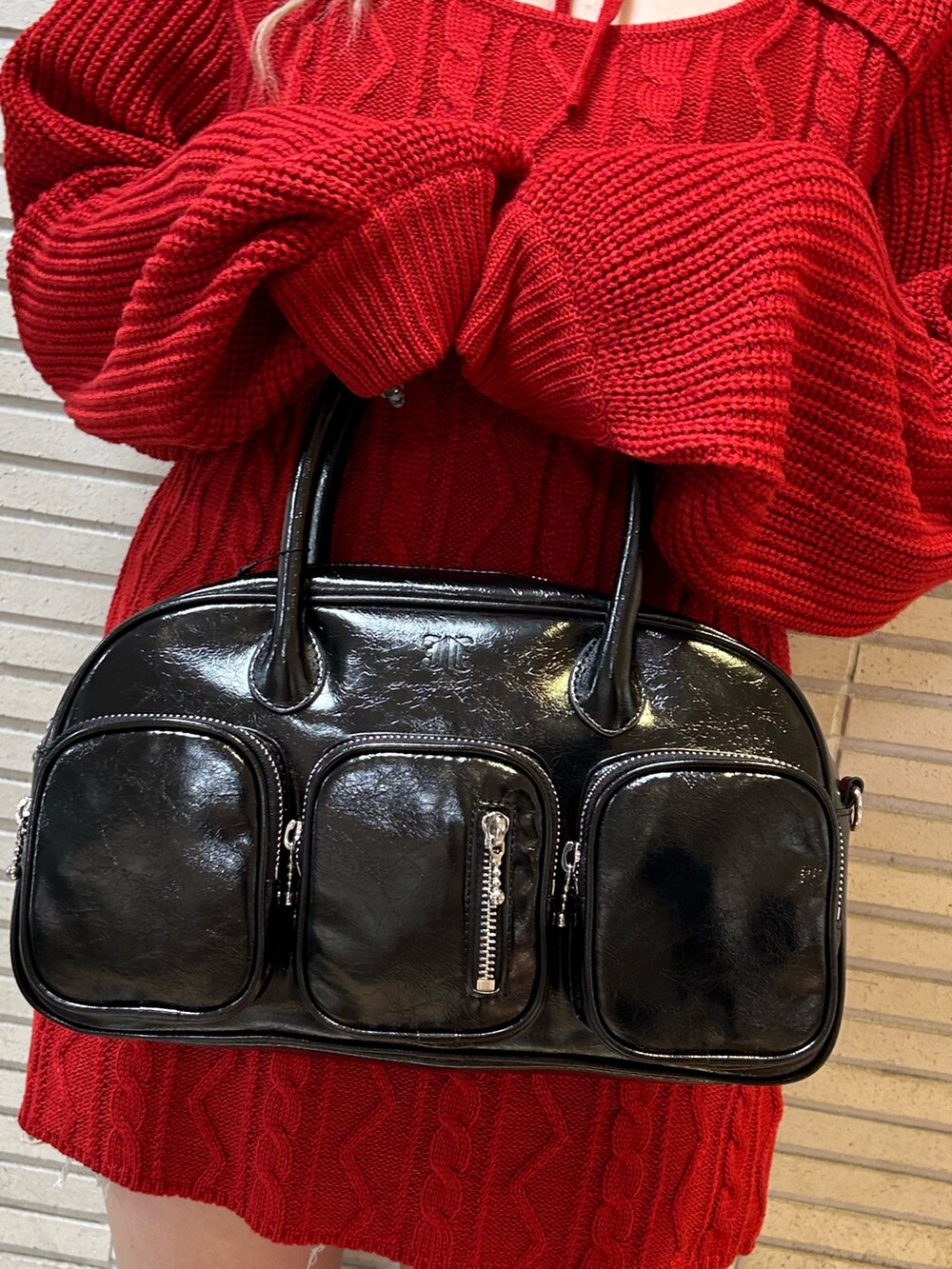 ブラック系のブーツ、ブラック系のボストンバッグ、レッド系のワンピースを着用したレディースの秋コーディネートの7枚目の写真
