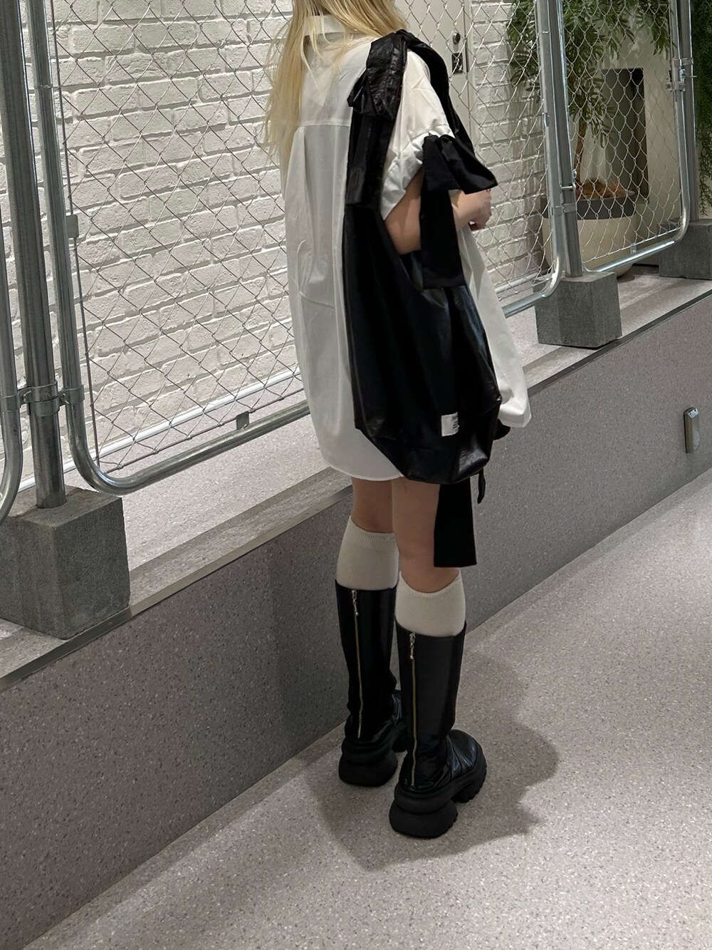 ブラック系のトートバッグ、ホワイト系のシャツ/ブラウス、ブラック系のチョーカーを着用したレディースの夏コーディネートの3枚目の写真