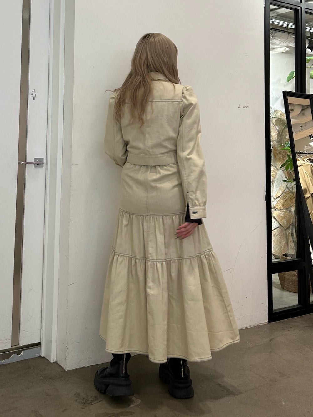 ブラック系のシャツ/ブラウス、ホワイト系のワンピース、ブラック系のブーツを着用したレディースの冬コーディネートの2枚目の写真