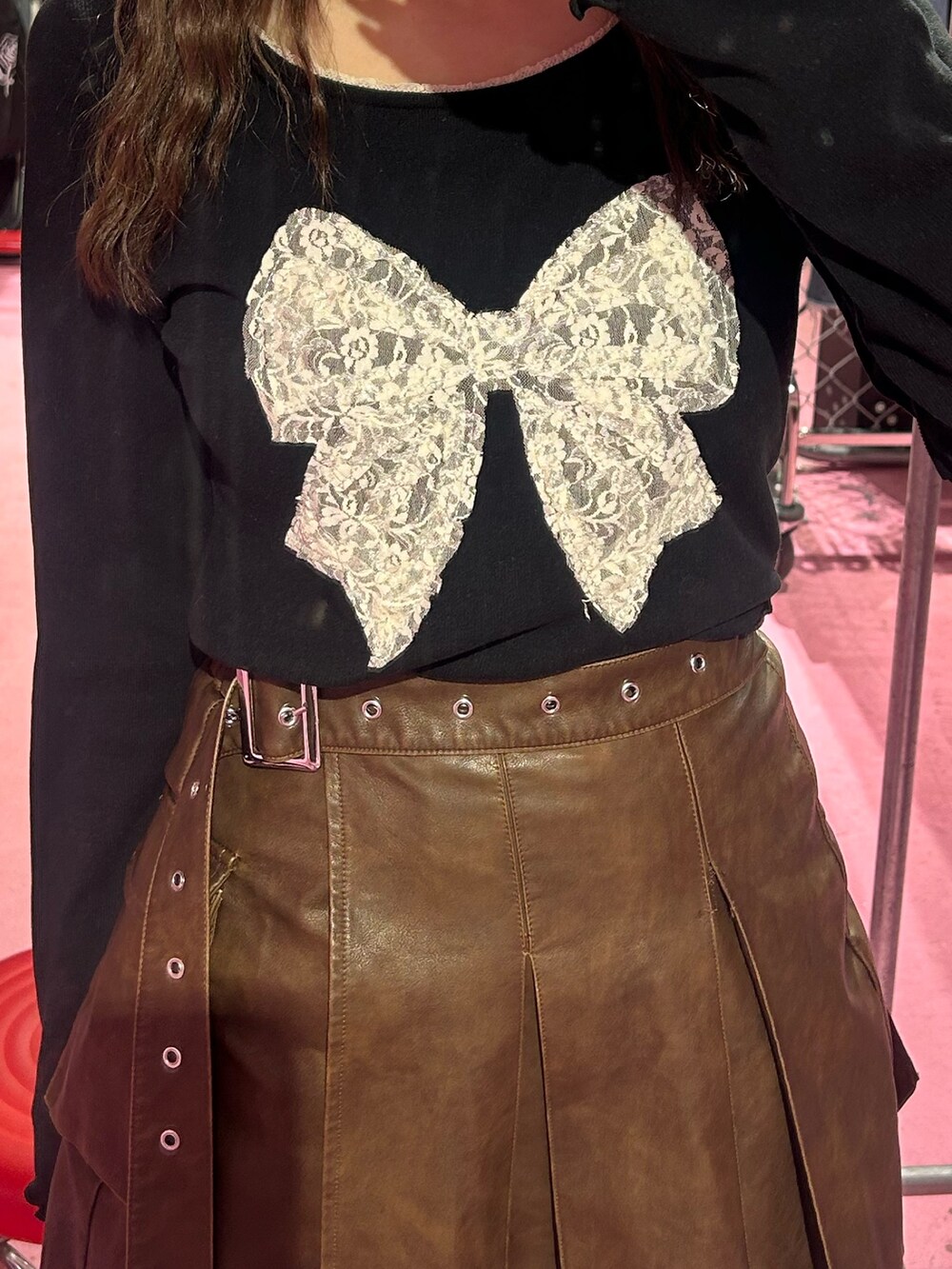 ブラック系のTシャツ/カットソー、ブラウン系のスカート、ブラウン系のブーツを着用したレディースの秋コーディネートの5枚目の写真