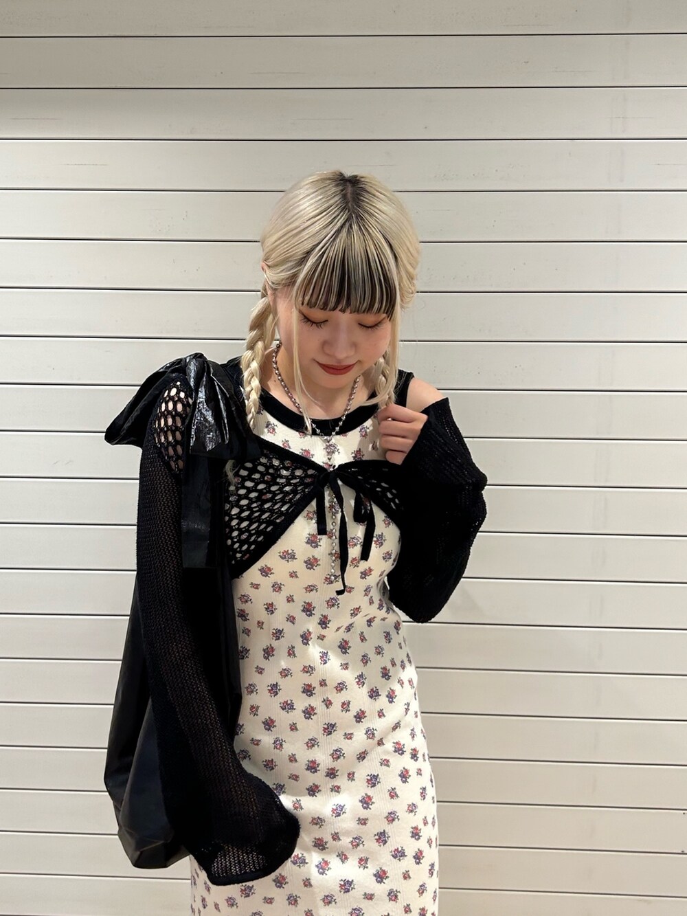 ホワイト系のワンピース、ブラック系のトートバッグ、ブラック系のカーディガン/ボレロを着用したレディースの春コーディネートの4枚目の写真