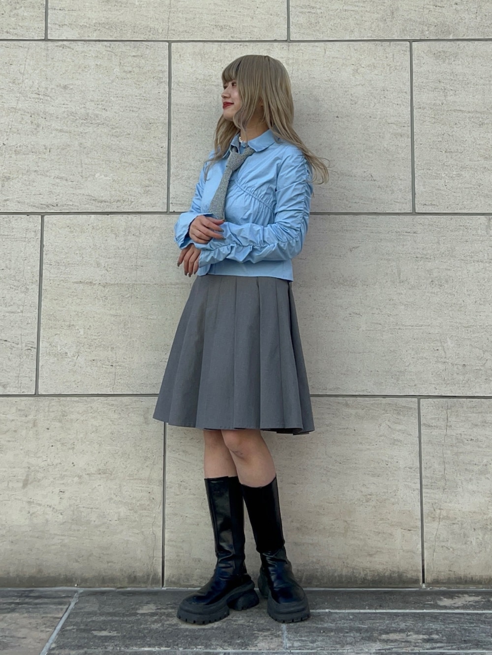 シルバー系のネクタイ、グレー系のスカート、ブラック系のブーツを着用したレディースの冬コーディネートの2枚目の写真